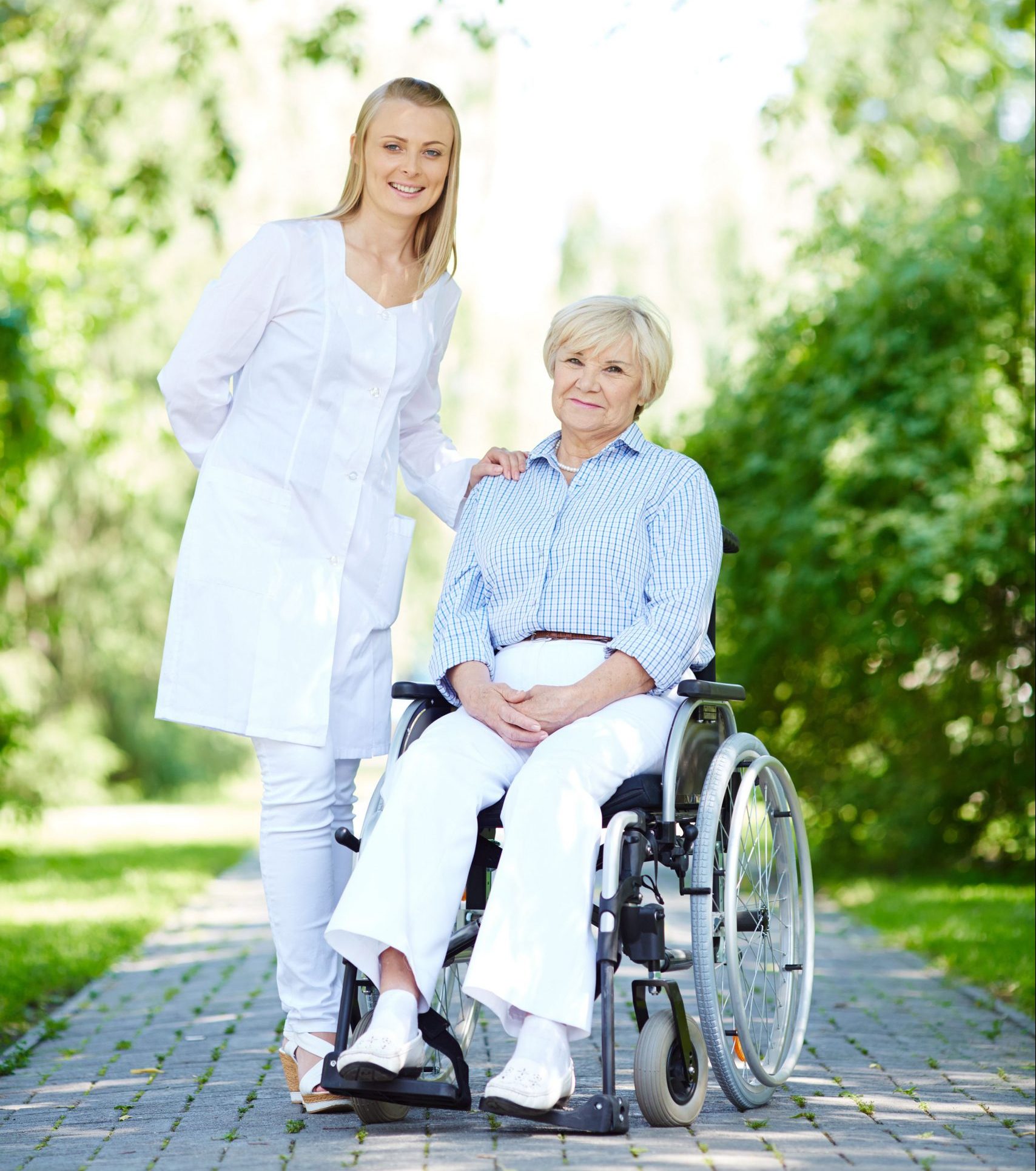 Pretty nurse taking care of senior patient while taking walk in park